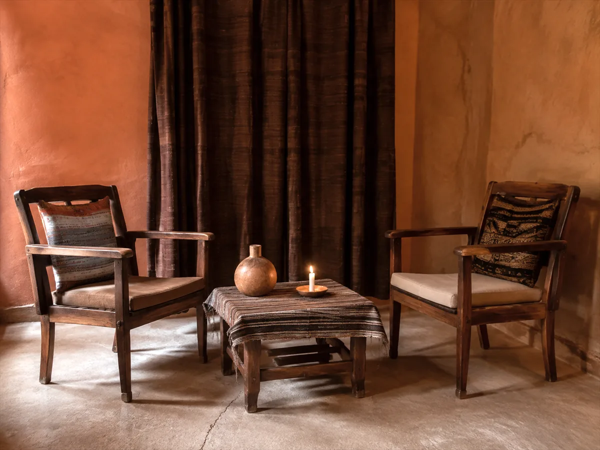 Pièce de consultation calme avec deux fauteuils face à face, une table basse et une bougie qui brûle